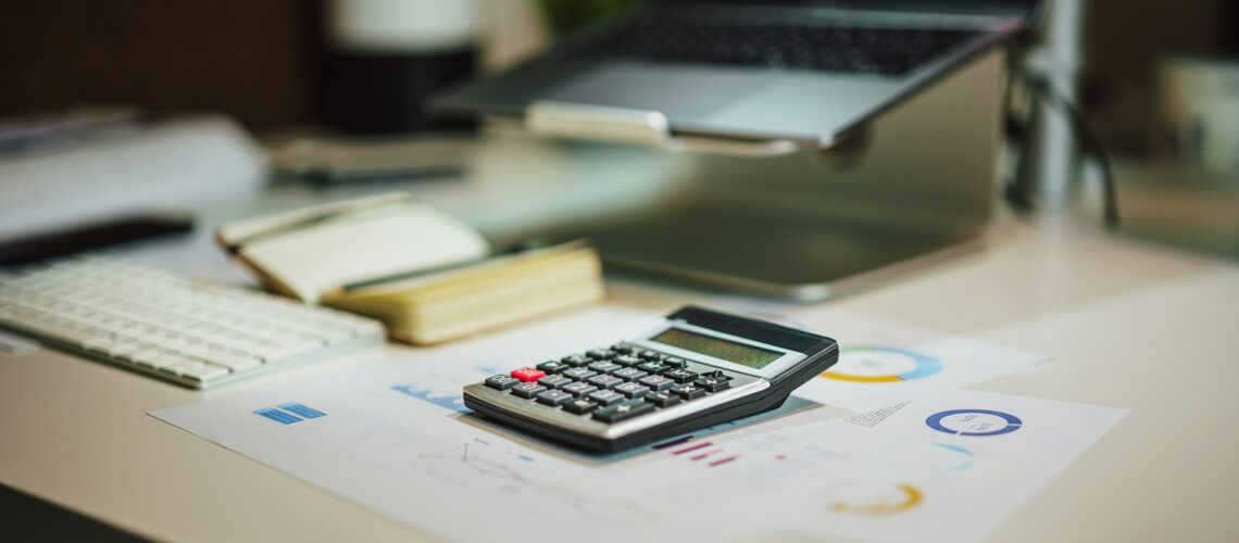 a calculator sitting on top of a table next to a laptop