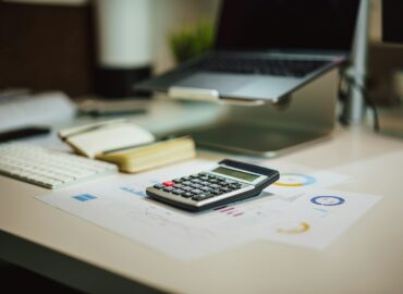 a calculator sitting on top of a table next to a laptop