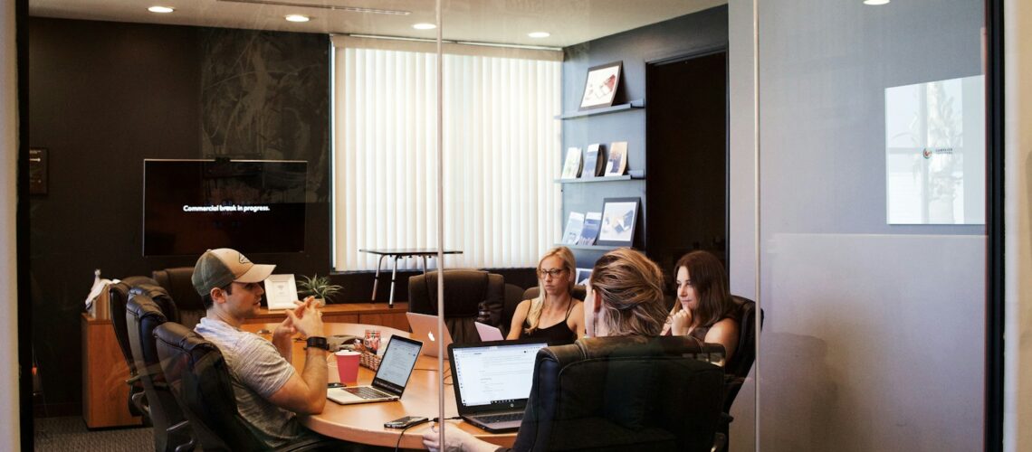 people sitting near table with laptop computer