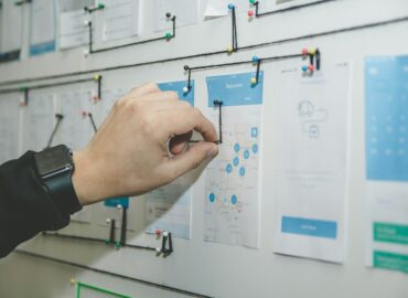 person working on blue and white paper on board